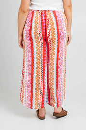 Model Poppy wearing size 16 of the Moon Bay Cotton Pants in colour Multipink (Pink), from the back