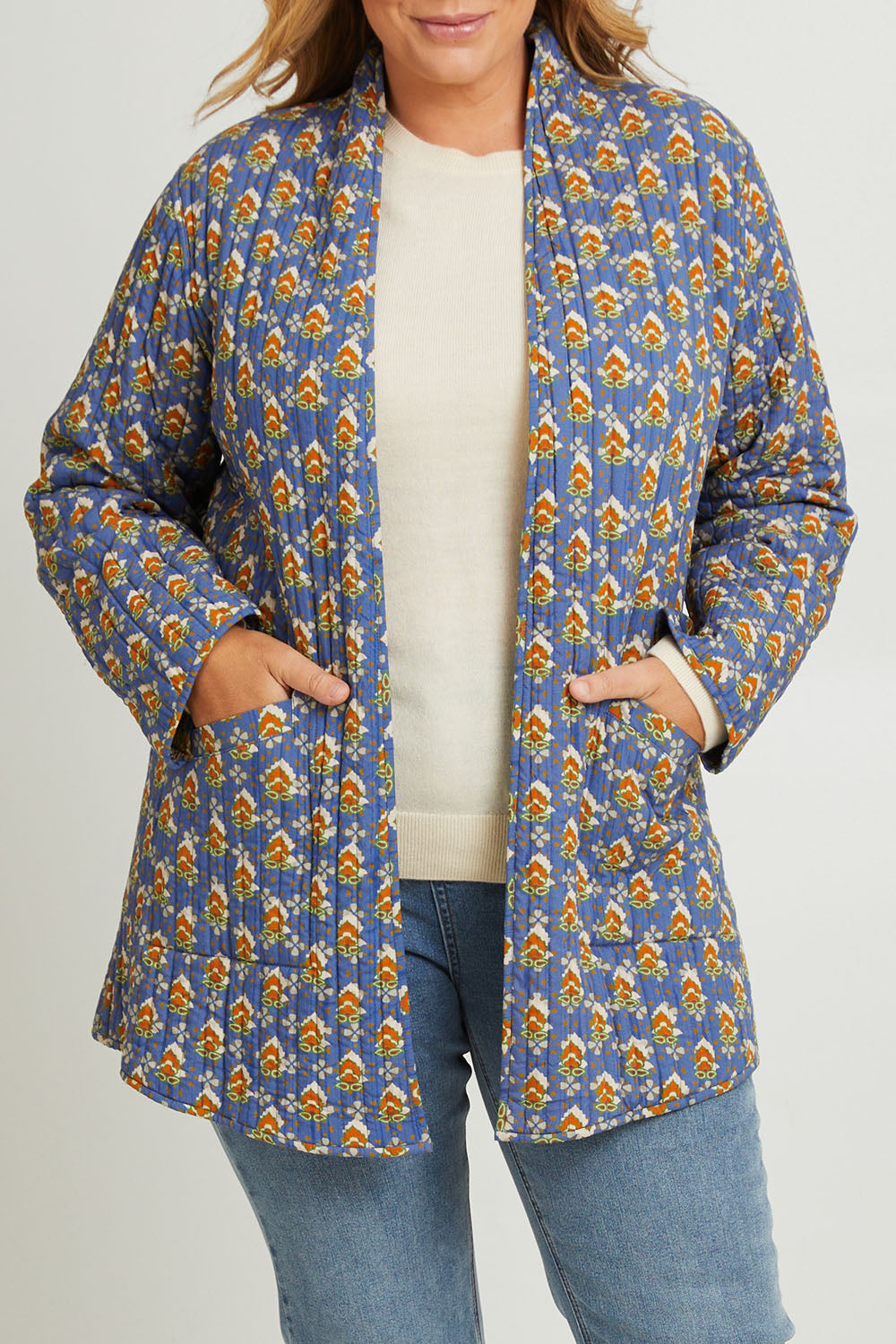 Model Fiona wearing size 16 of the Brighton Beach Reversible Jacket in colour Patchblue (Blue), from the front, cropped image