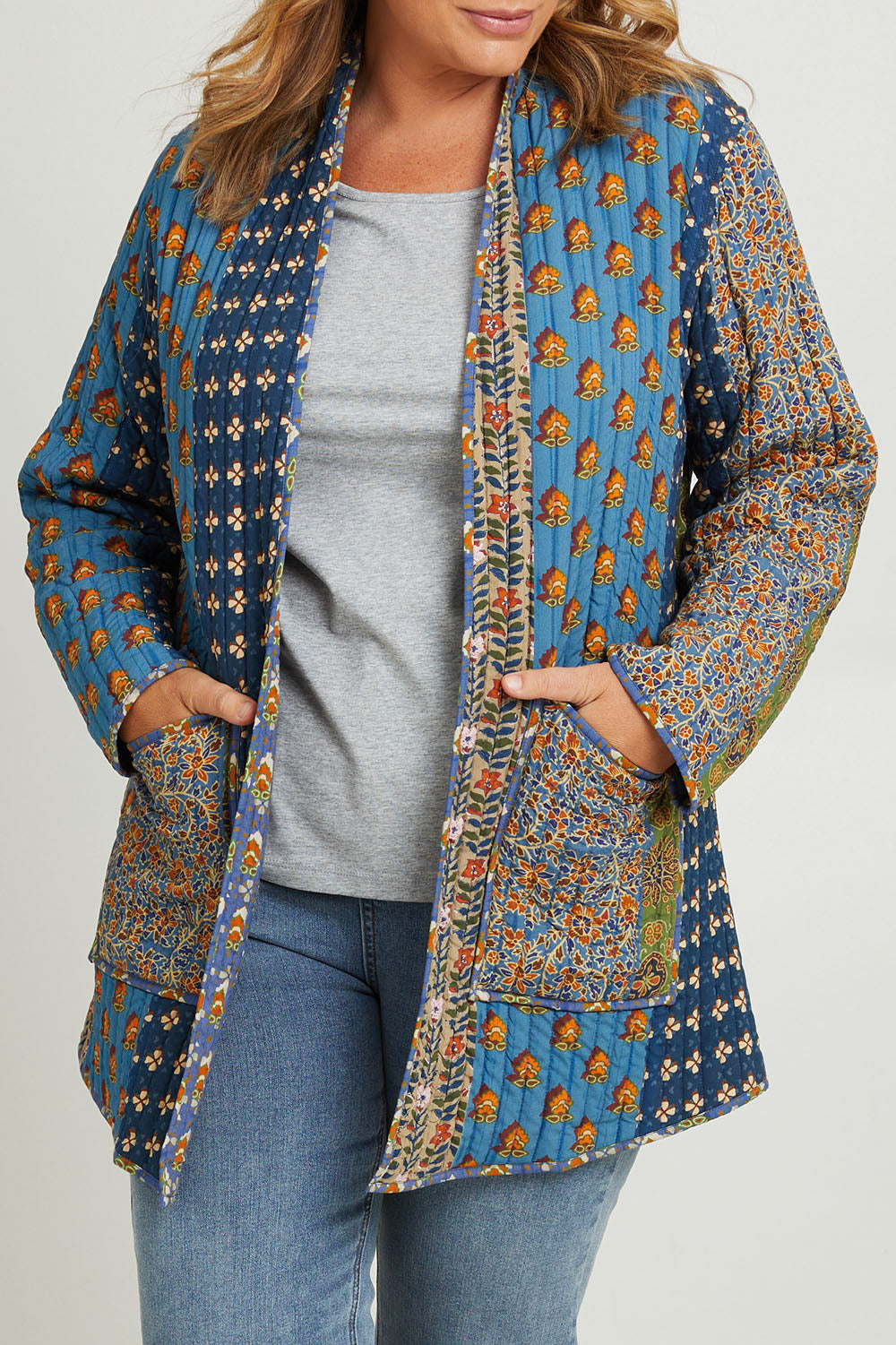 Model Fiona wearing size 16 of the Brighton Beach Reversible Jacket in colour Patchblue (Blue), from the front, cropped image