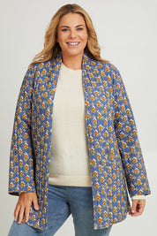 Model Fiona wearing size 16 of the Brighton Beach Reversible Jacket in colour Patchblue (Blue), from the front, cropped image