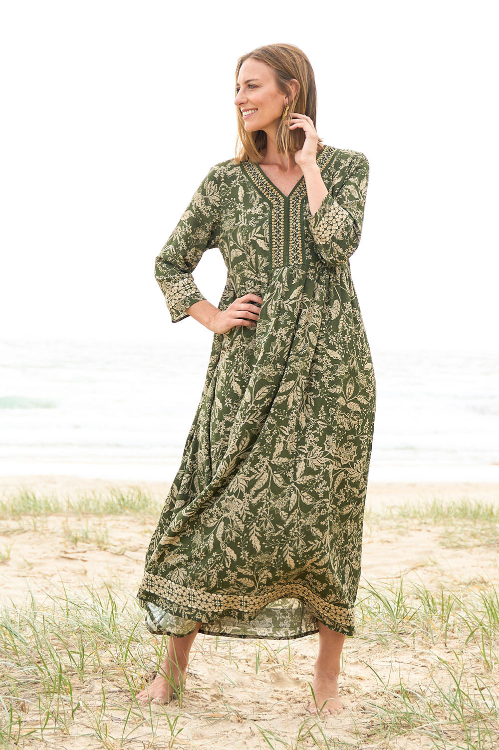 Model Riina wearing size 10 of the Greenly Beach Dress in colour Green (Green), from the front, showing the whole outfit