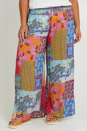 Model Ashleigh wearing size 16 of the Burleigh Beach Pant in colour Patchmulti, from the front, cropped image