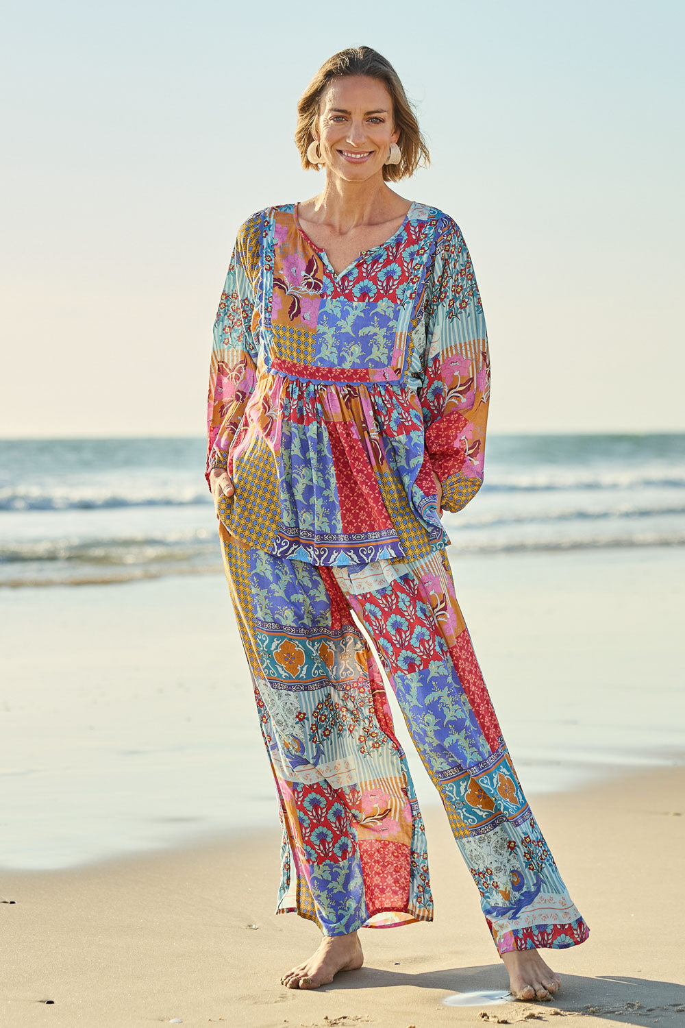 Model Riina wearing size 10 of the Burleigh Beach Pant in colour Patchmulti, from the front, showing the whole outfit
