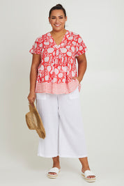 Model Ashleigh wearing size 16 of the Kurrawa Beach Cotton Top in colour Redcoral (Red), from the front, showing the whole outfit