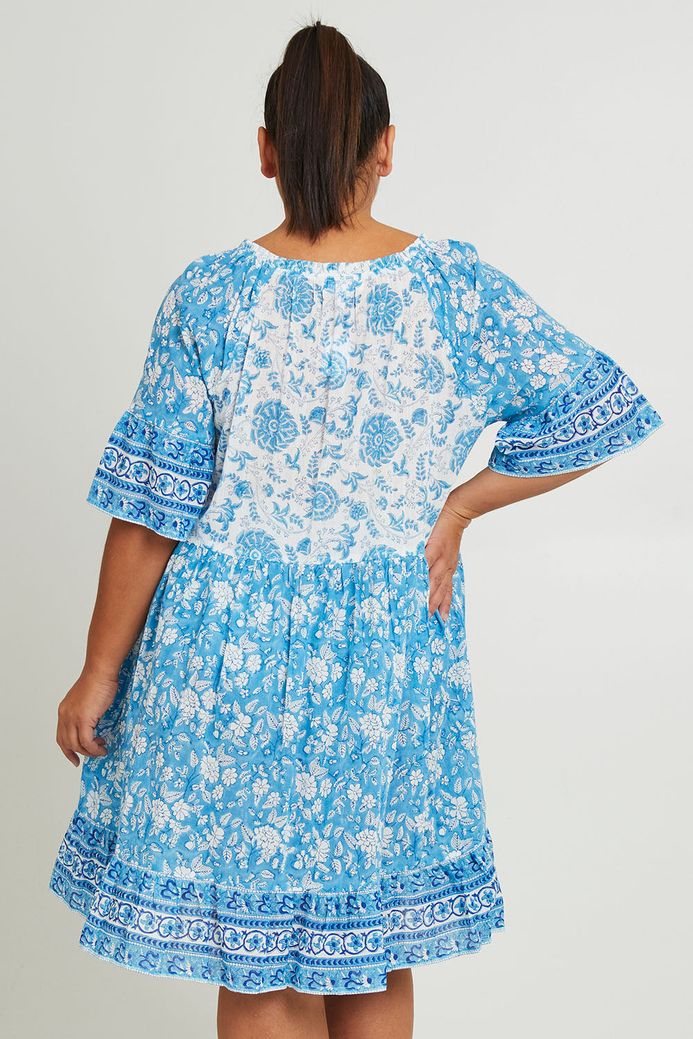 Model Ashleigh wearing size 16 of the Cottesloe Beach Cotton Dress in colour Bluefloral (Blue), from the back