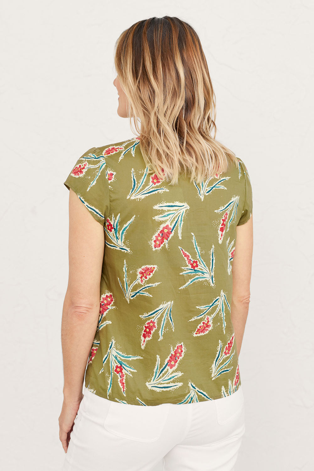 A model wearing the Garden Gate Top in colour Lxiaflower (Green), from the back