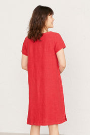 A model wearing the Okanum Dress in colour Squash (Red), from the back