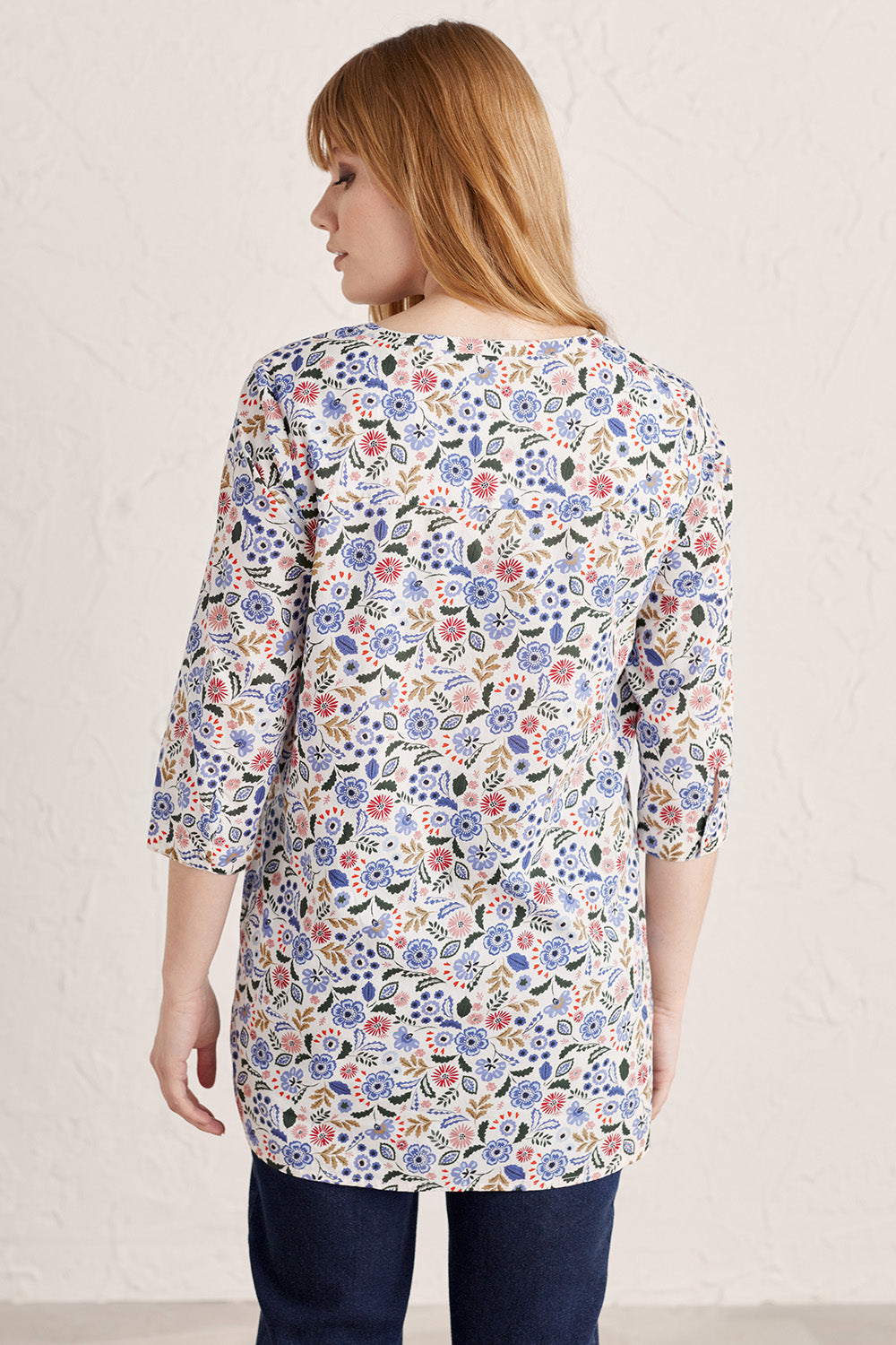 A model wearing the Adventurier Tunic in colour Floral (White), from the back