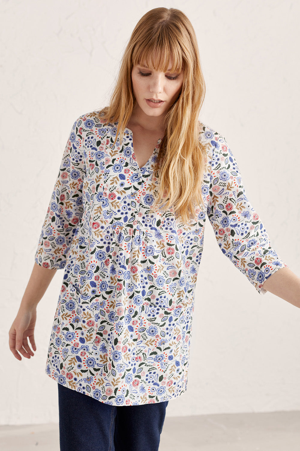 A model wearing the Adventurier Tunic in colour Floral (White), from the front, cropped image