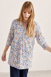 A model wearing the Adventurier Tunic in colour Floral (White), from the front, cropped image