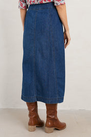 A model wearing the Dusk Journey Skirt in colour Midindigo (Blue), from the back