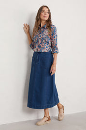 A model wearing the Dusk Journey Skirt in colour Midindigo (Blue), from the front, showing the whole outfit