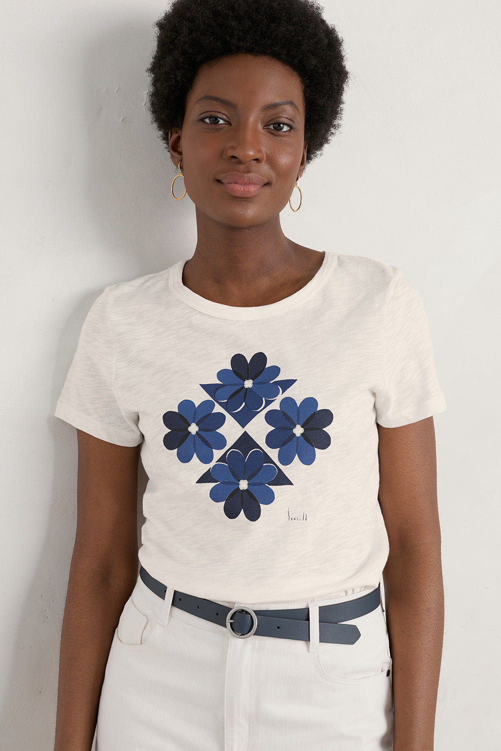 A model wearing the Printing Ink Tin colourShirt - Tiledflora (White), from the front, cropped image
