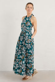 A model wearing the Summer Soul Dress in colour Peony (Green), from the front, showing the whole outfit