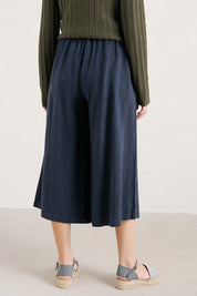 A model wearing the Intertidal Culottes in colour Maritime (Blue), from the back