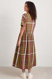 A model wearing the Brouse Dress in colour Clover (Green), from the back