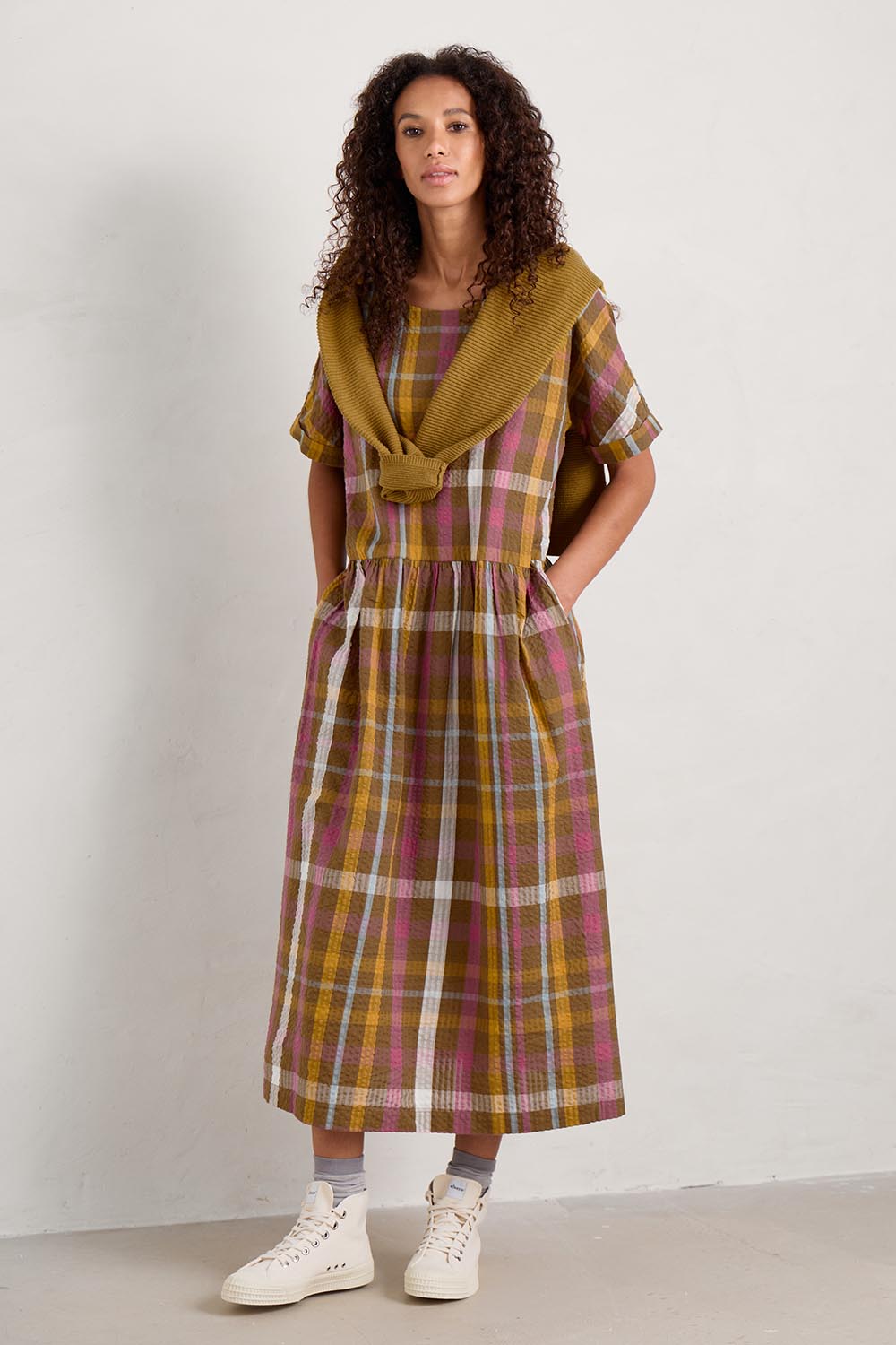 A model wearing the Brouse Dress in colour Clover (Green), from the front, showing the whole outfit