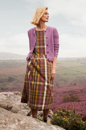 A model wearing the Brouse Dress in colour Clover (Green), from the front, showing the whole outfit