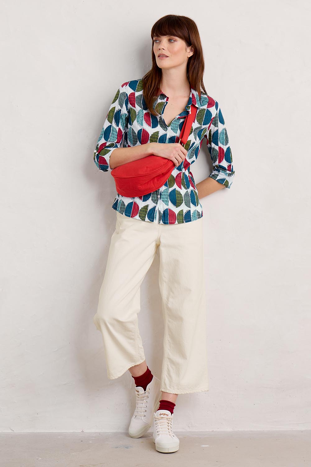 A model wearing the Larissa Shirt in colour Circle (Blue), from the front, showing the whole outfit