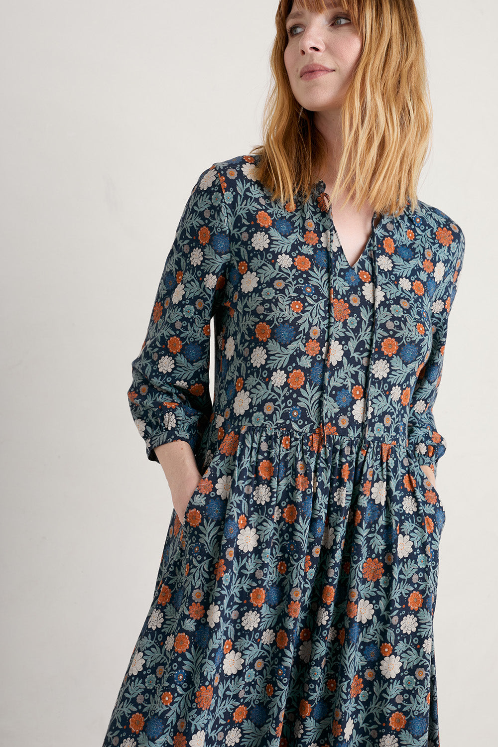 A model wearing the Fox Page Dress in colour Bloom (Blue), from the front, cropped image