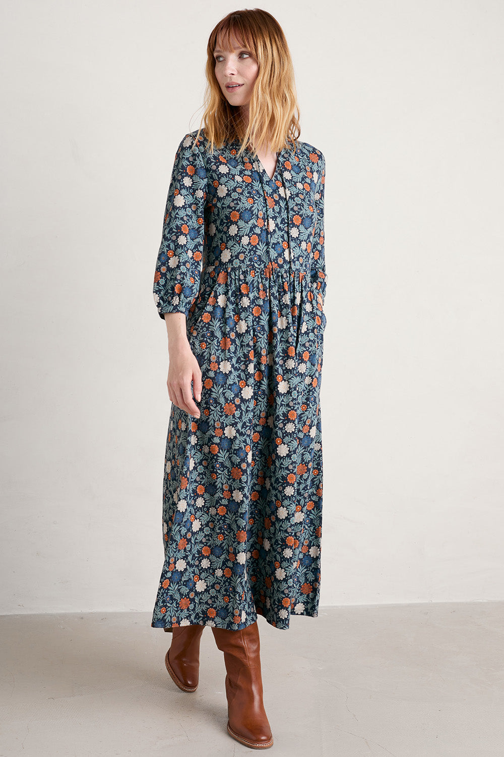A model wearing the Fox Page Dress in colour Bloom (Blue), from the front, showing the whole outfit