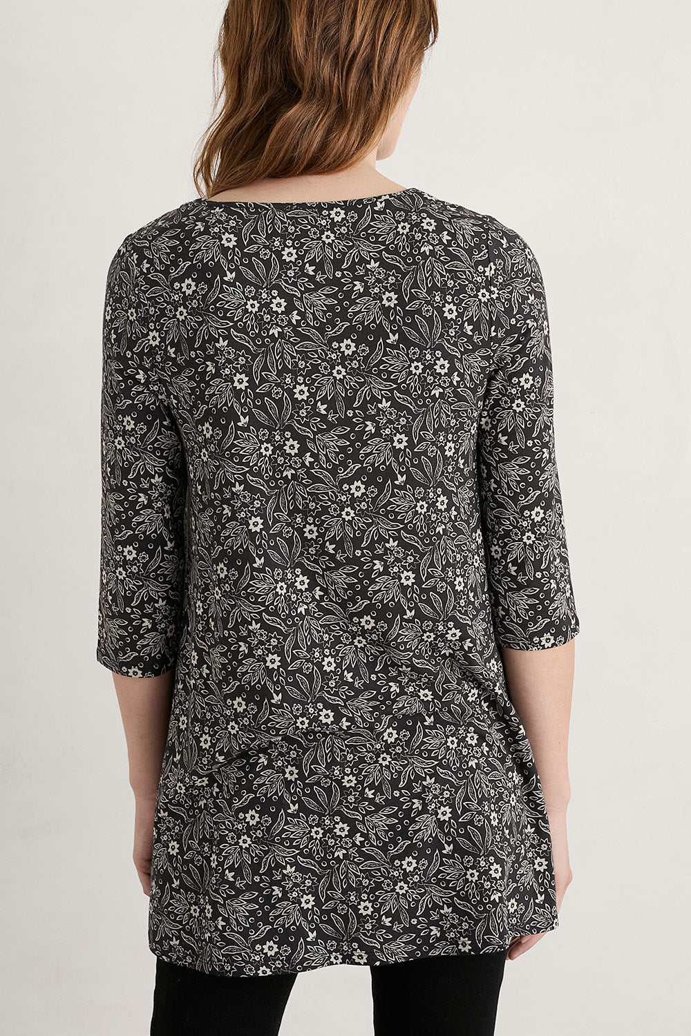 A model wearing the Arusha Tunic in colour Leaves (Black), from the back