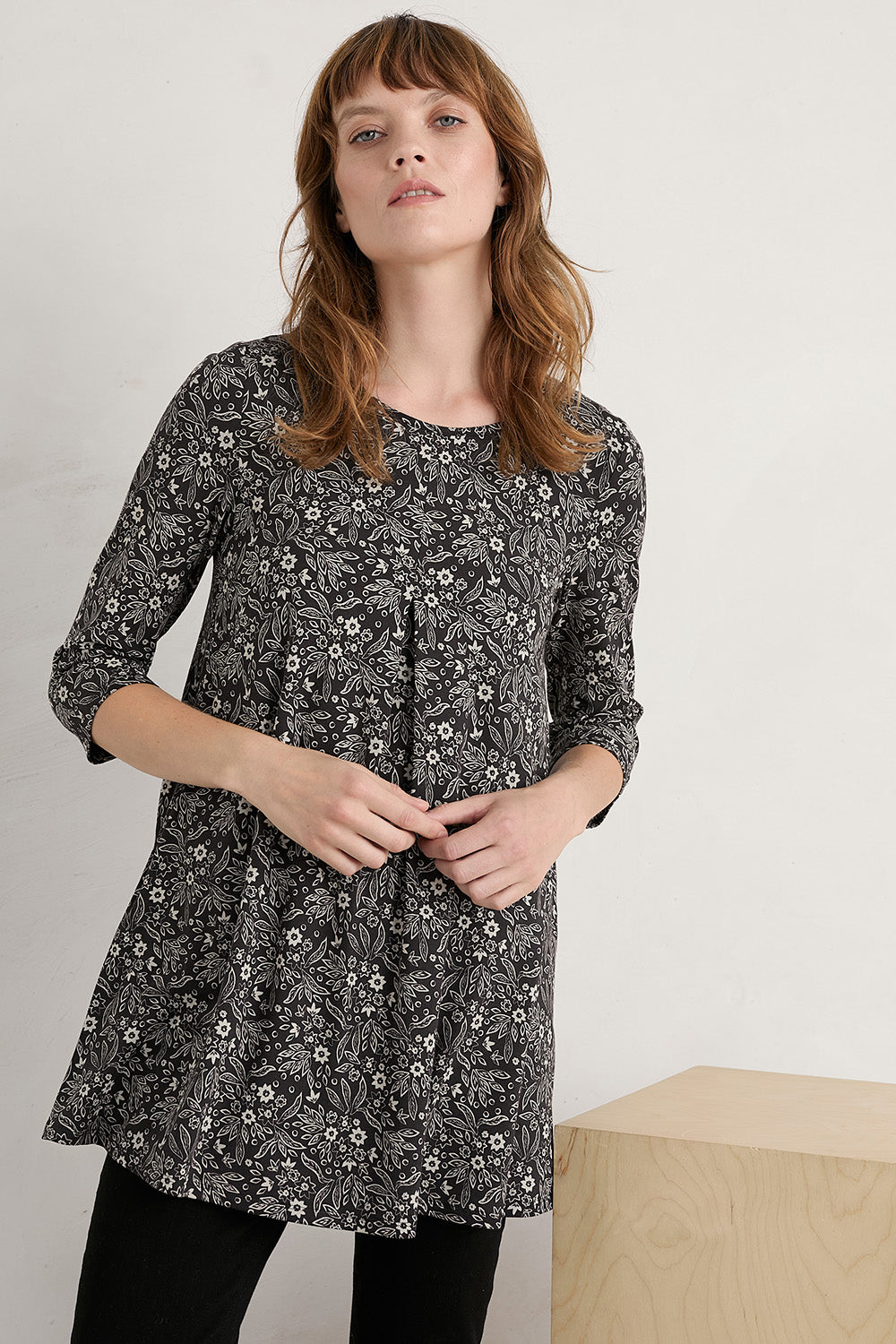 A model wearing the Arusha Tunic in colour Leaves (Black), from the front, cropped image