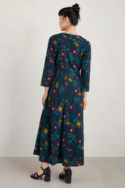 A model wearing the Willow Blossom Dress in colour Floral (Blue), from the back
