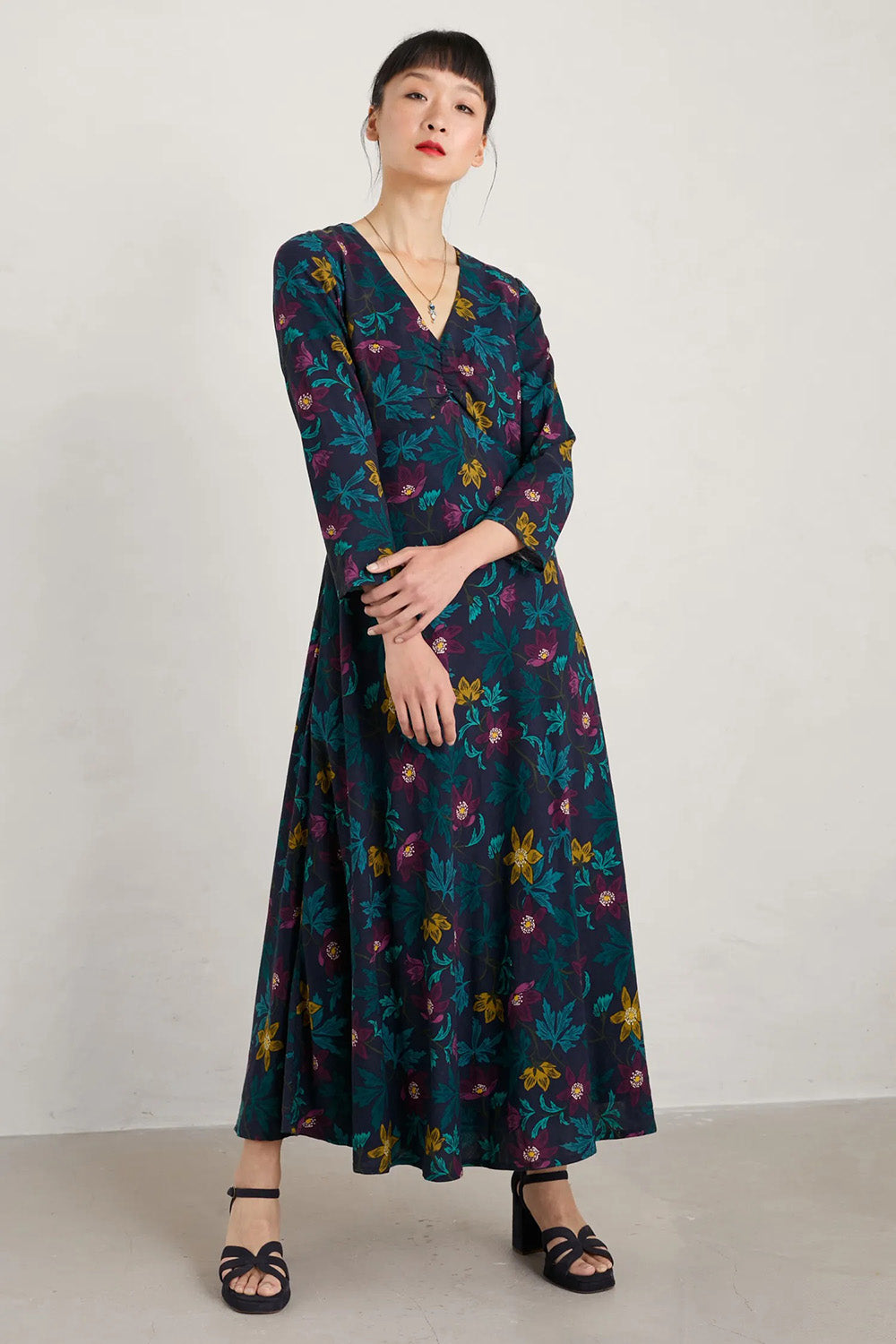 A model wearing the Willow Blossom Dress in colour Floral (Blue), from the front, showing the whole outfit