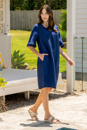 A model wearing the Flutter Sleeve Dress in colour Navy (Blue), from the front, showing the whole outfit