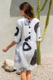 A model wearing the Linen 3/4 Sleeve Dress in colour Achromatic (White), from the back