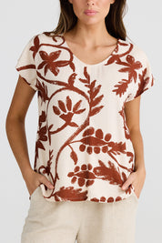 A model wearing the Havana Tee in colour Cubanbloom, from the front, cropped image