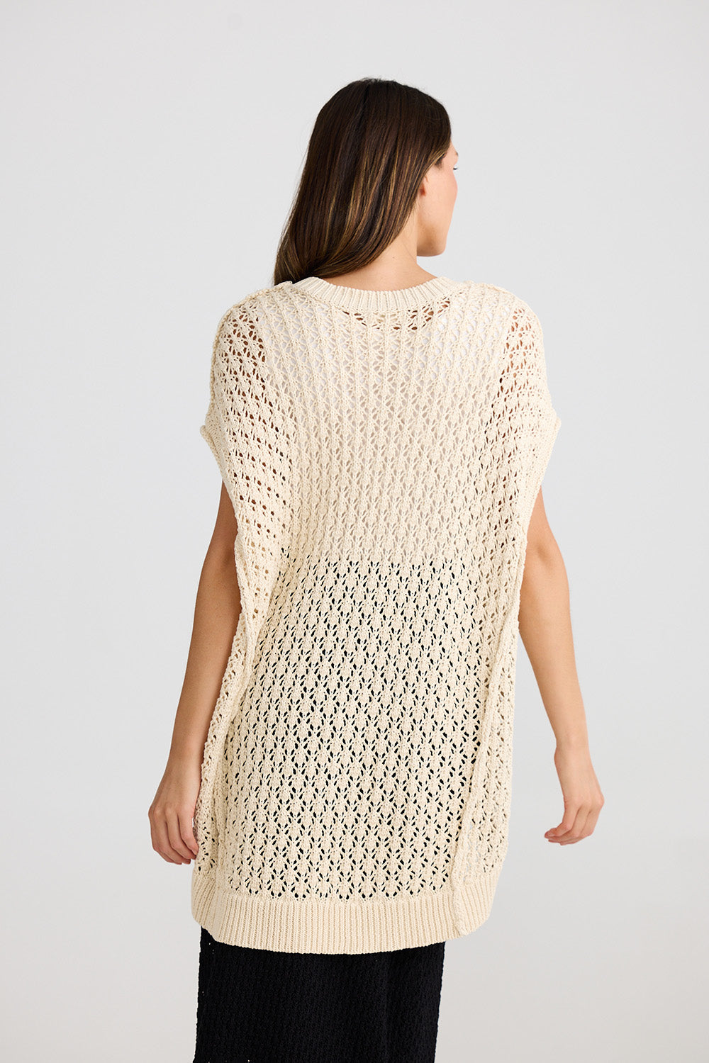A model wearing the Kasbah Top in colour Natural, from the back