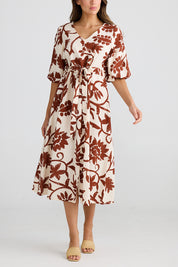 A model wearing the Ava Midi Dress in colour Cubanbloom, from the front, cropped image