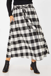 Model Jess wearing size L of the Natalia Skirt in colour Blkwhite (Black), from the front, cropped image