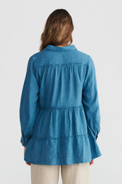 A model wearing the Mia Top in colour Bluesteel (Blue), from the back