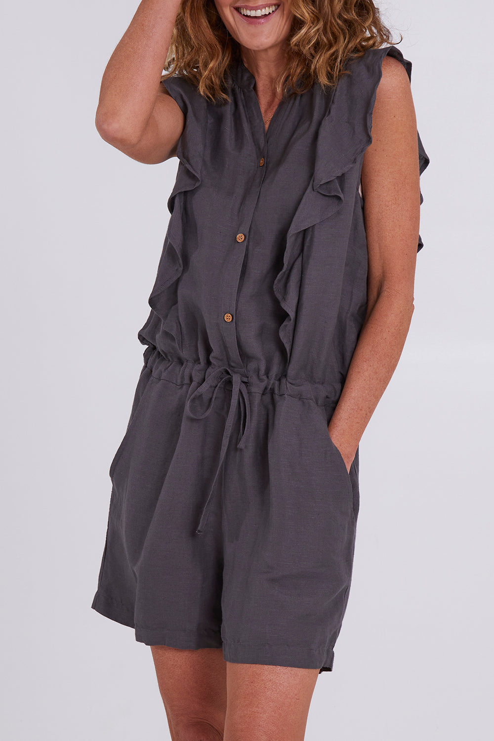 Model Emma wearing size S of the Mandalay Jumpsuit in colour Charcoal (Grey), from the front, cropped image