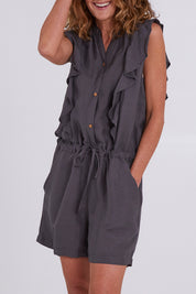 Model Emma wearing size S of the Mandalay Jumpsuit in colour Charcoal (Grey), from the front, cropped image