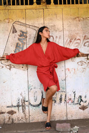 A model wearing the Porto Linen Dress in colour Cherry (Red), from the front, showing the whole outfit