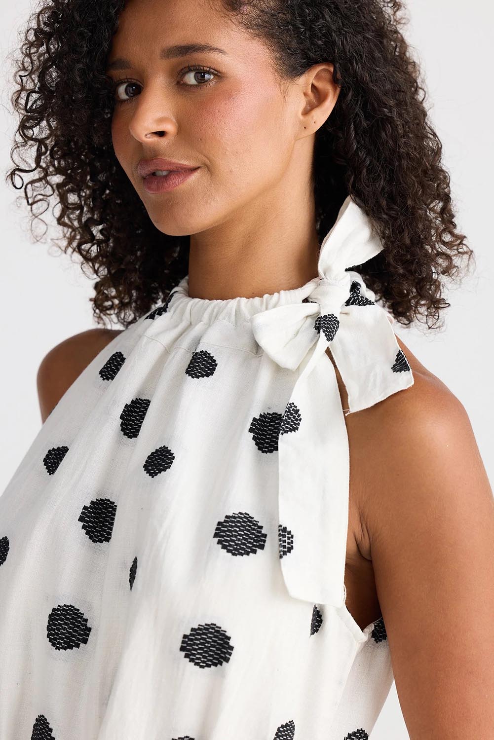 A model wearing the Lucia Linen Cotton Dress in colour Wovenspot (White), from the front, cropped image