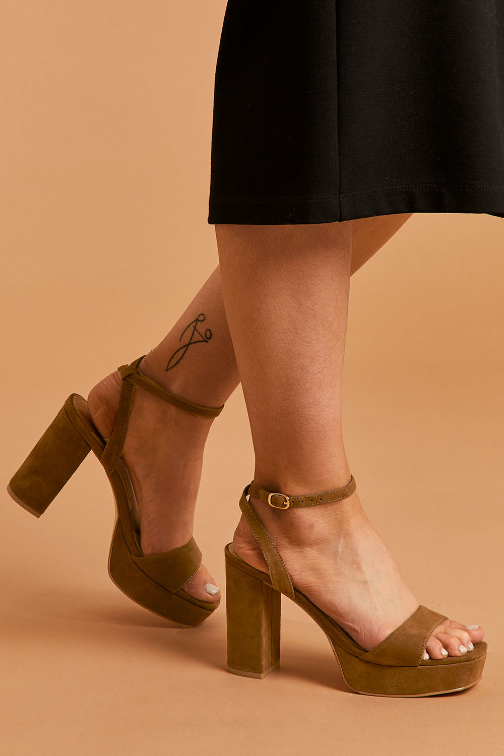 A model wearing size 38 of the Orion Platform Heel in colour Coffee, from the front, cropped image
