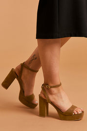 A model wearing size 38 of the Orion Platform Heel in colour Coffee, from the front, cropped image