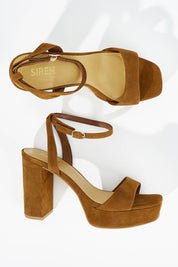 A model wearing size 38 of the Orion Platform Heel in colour Coffee, from the front, showing the whole outfit