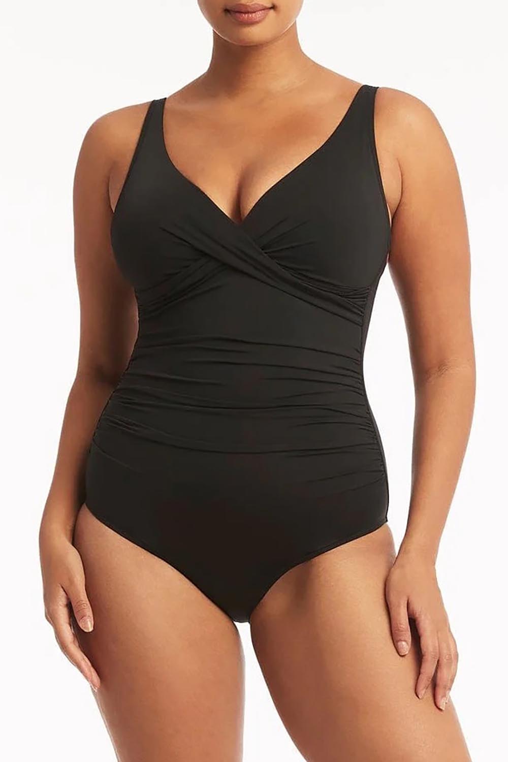A model wearing the Eco Essentials Cross Front One Piece in colour Black (Black), from the front, cropped image