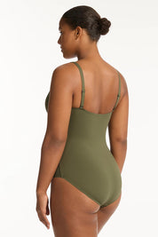 A model wearing the Eco Essentials Cross Front One Piece in colour Khaki (Green), from the back