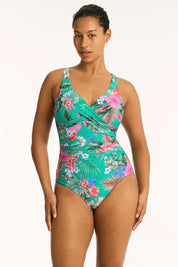 A model wearing the Cross Front Multifit One Piece in colour Evergreen (Green), from the front, cropped image