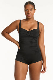A model wearing the Twist Front Multifit Boy Leg One Piece in colour Black (Black), from the front, cropped image