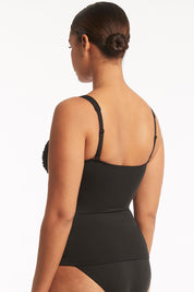 A model wearing the Twist Front Multifit Singlet Top in colour Black (Black), from the back