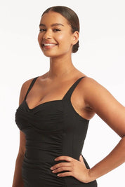 A model wearing the Twist Front Multifit Singlet Top in colour Black (Black), from the front, cropped image