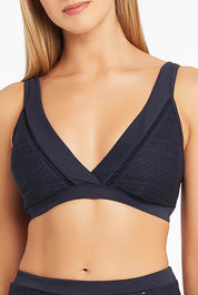 A model wearing the Amazing Lace Cross Front Panelled Bralette in colour Nightsky (Blue), from the front, cropped image